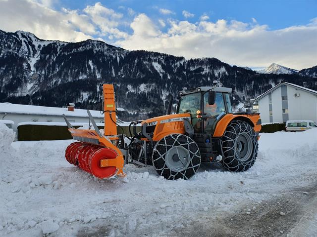 Ein Traktor mit angebauter Schneeschleuder